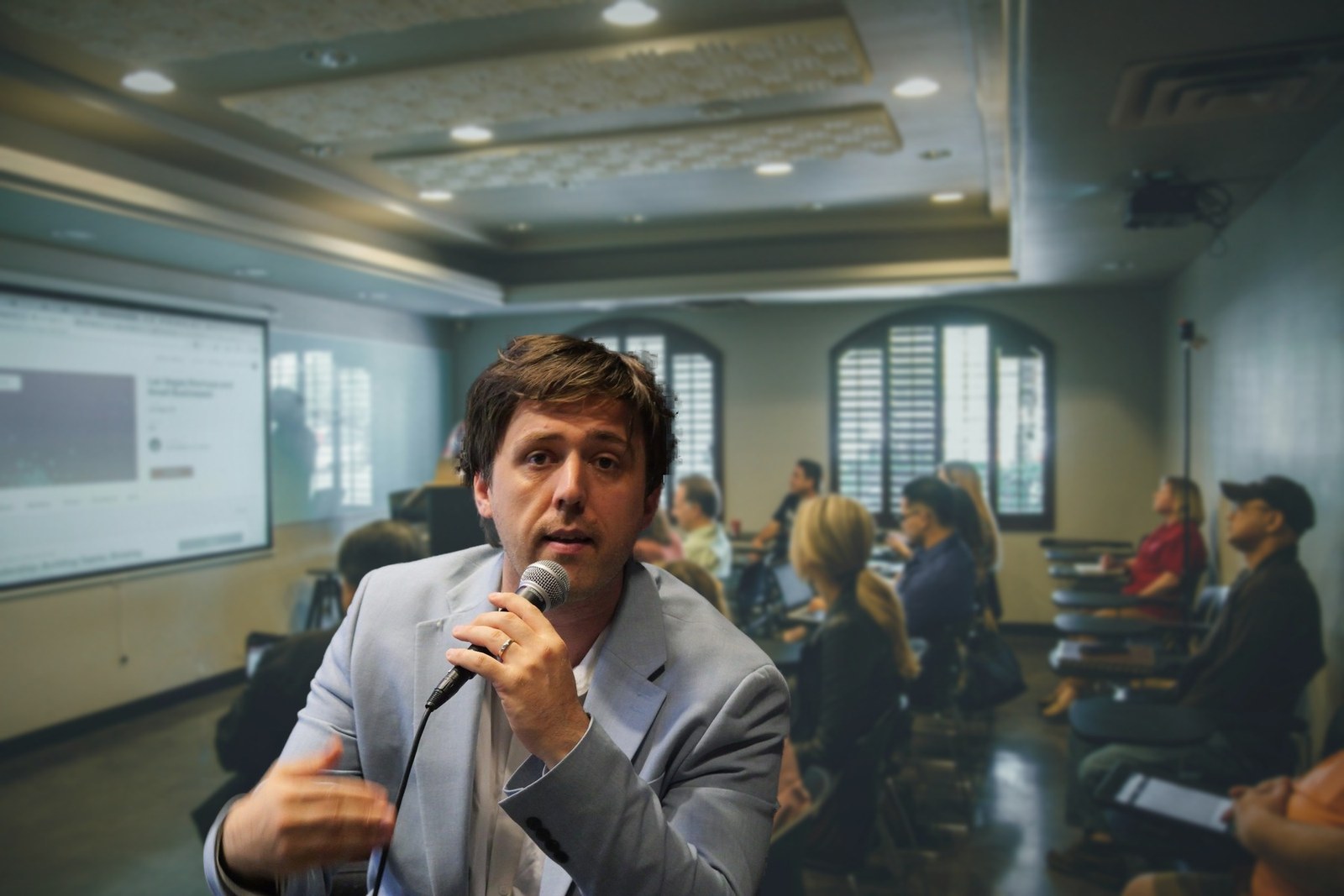Antonin Atger au micro, devant une salle de formation en entreprise