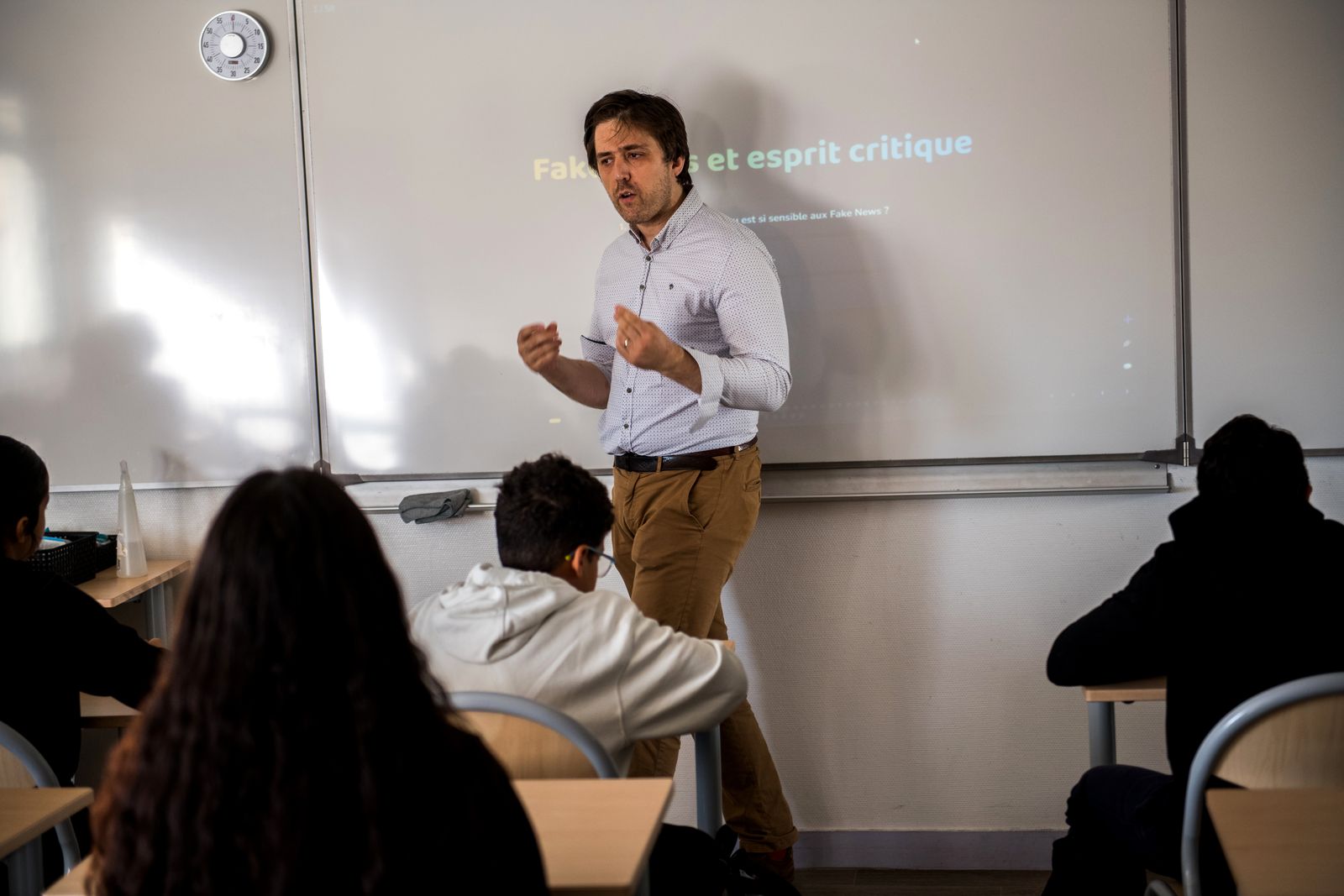 Antonin Atger devant l'écran titré « Fake news et esprit critique », face à une classe de collège